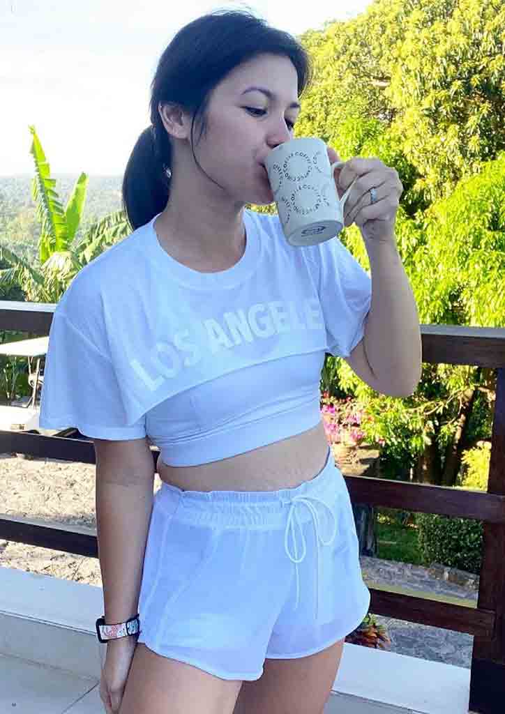 fit mom in white drinking coffee