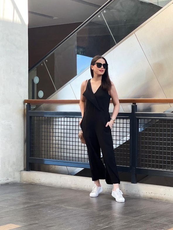 Maoui David's outfit with her white sneakers: a black jumpsuit.