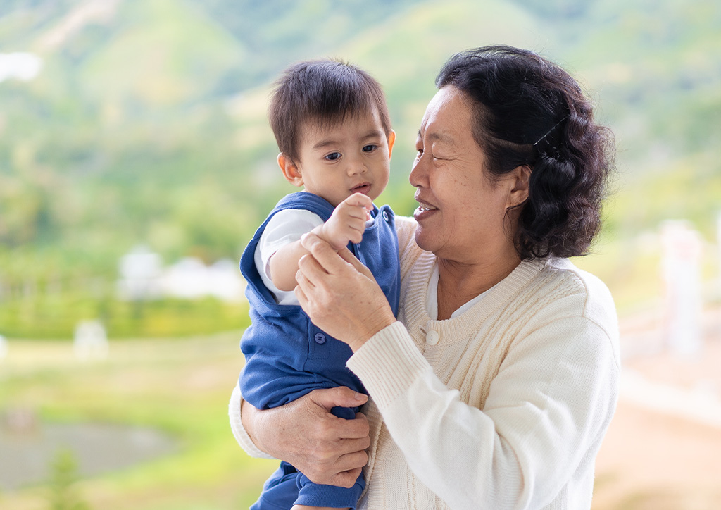 A baby boy and an elderly woman smiling