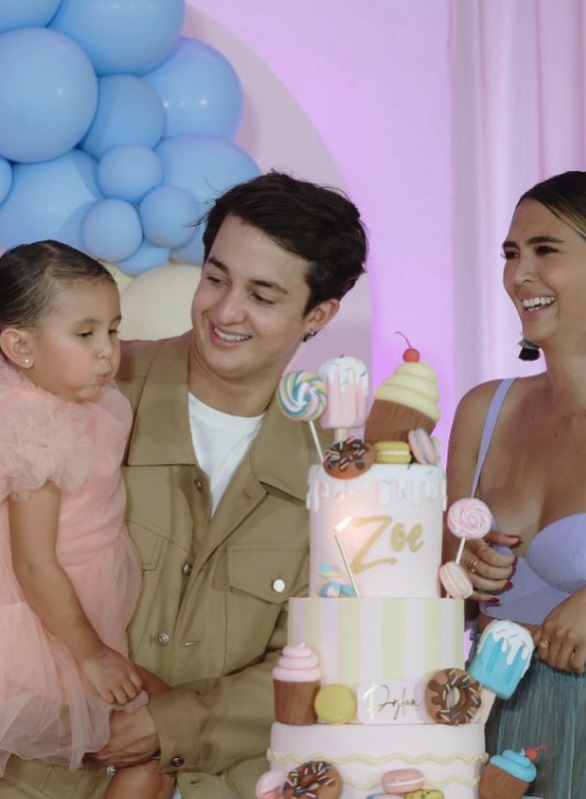 Zoe Miranda blowing out the candle on her birthday cake with Daniel Miranda and Sofia Andres.