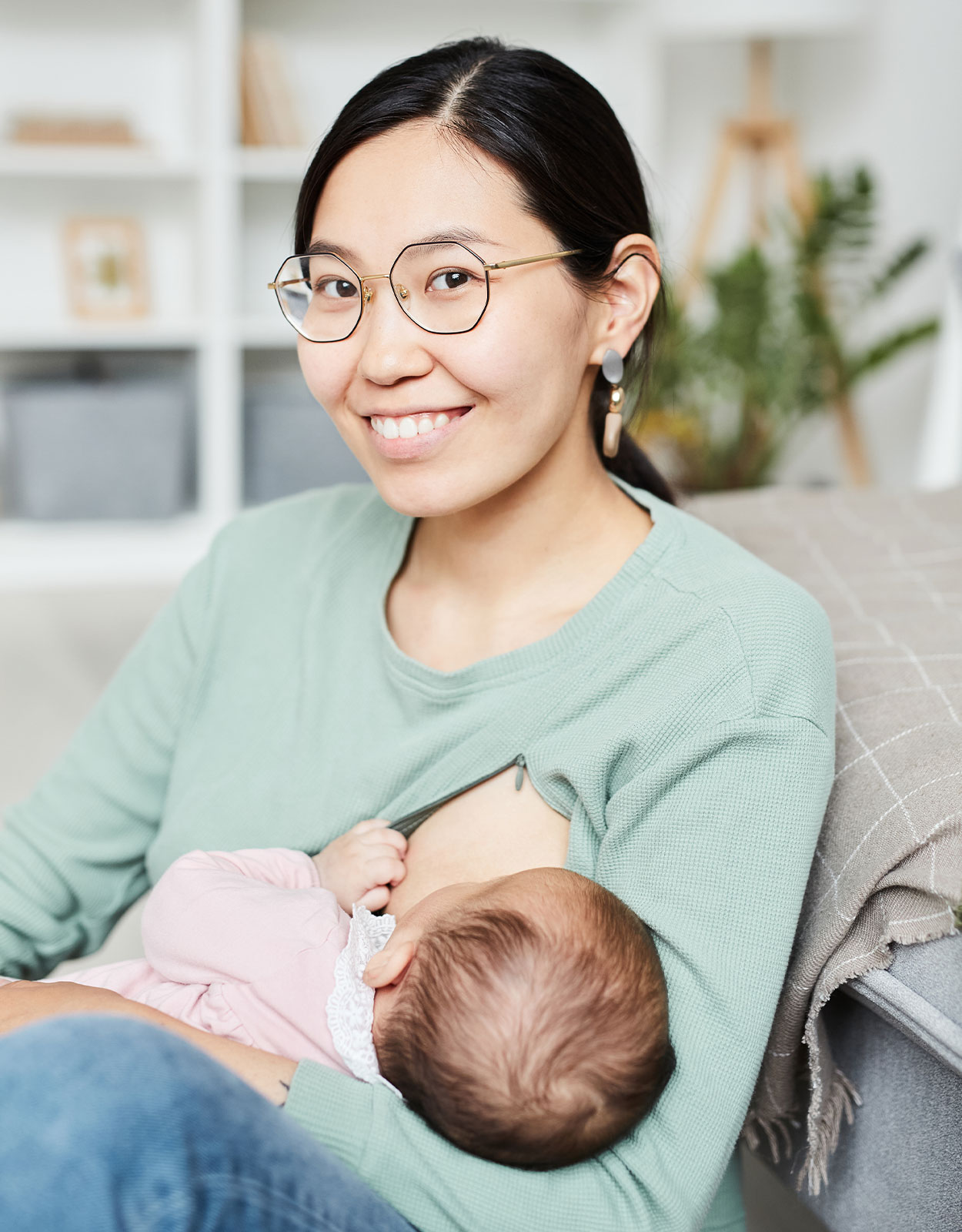 A mom holding a baby and wearing glasses
