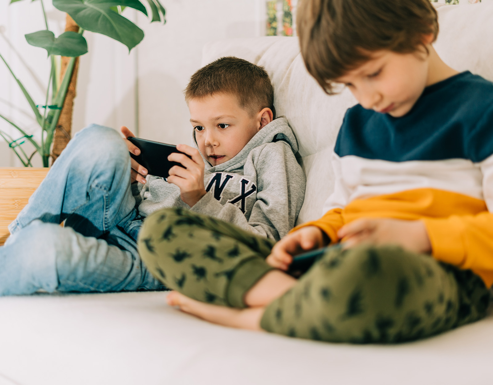 Two boys playing on their mobile phones