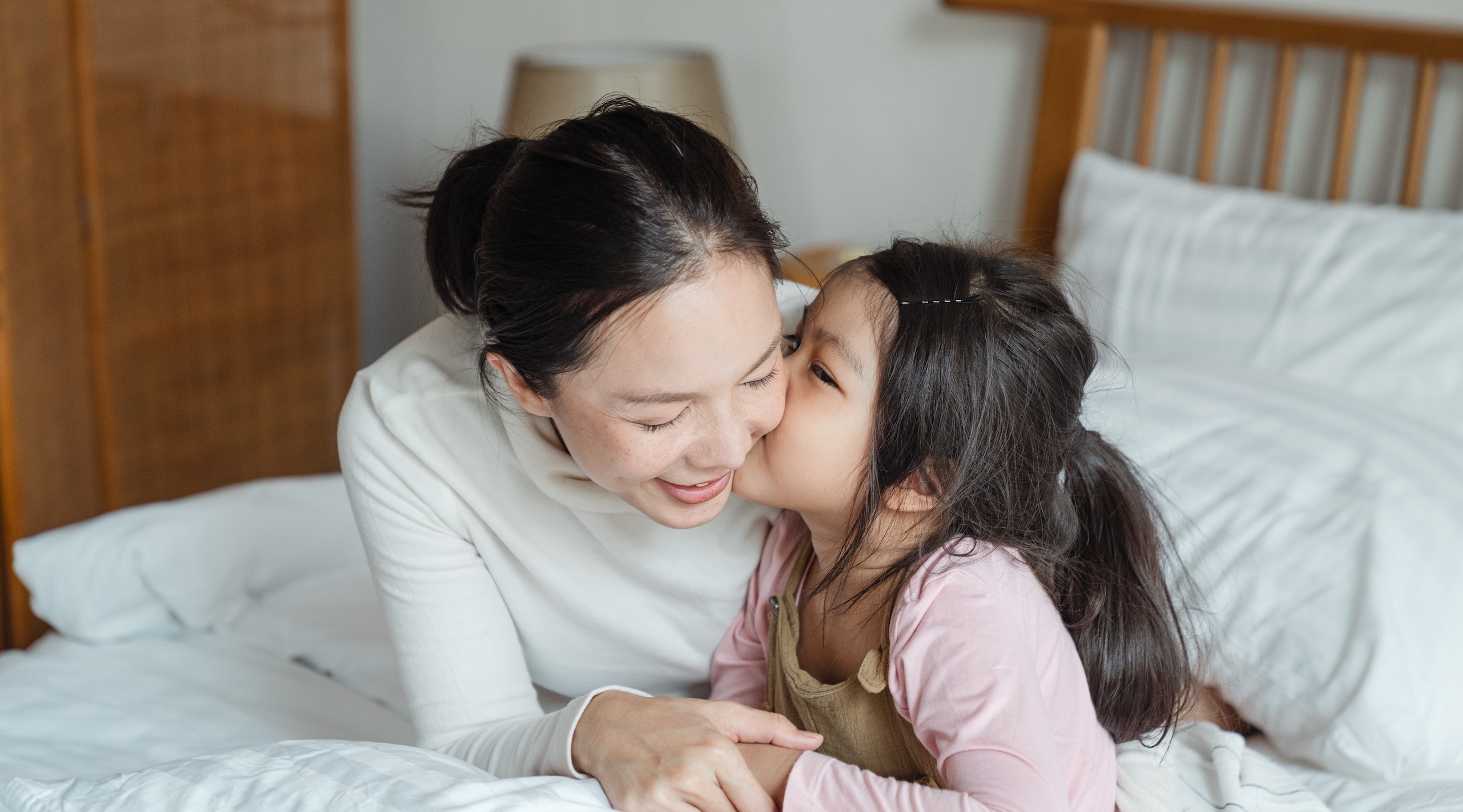 Asia moms. Мама китаянка. Мать и дочь в Китае. Девушка целует азиатского ребенка.