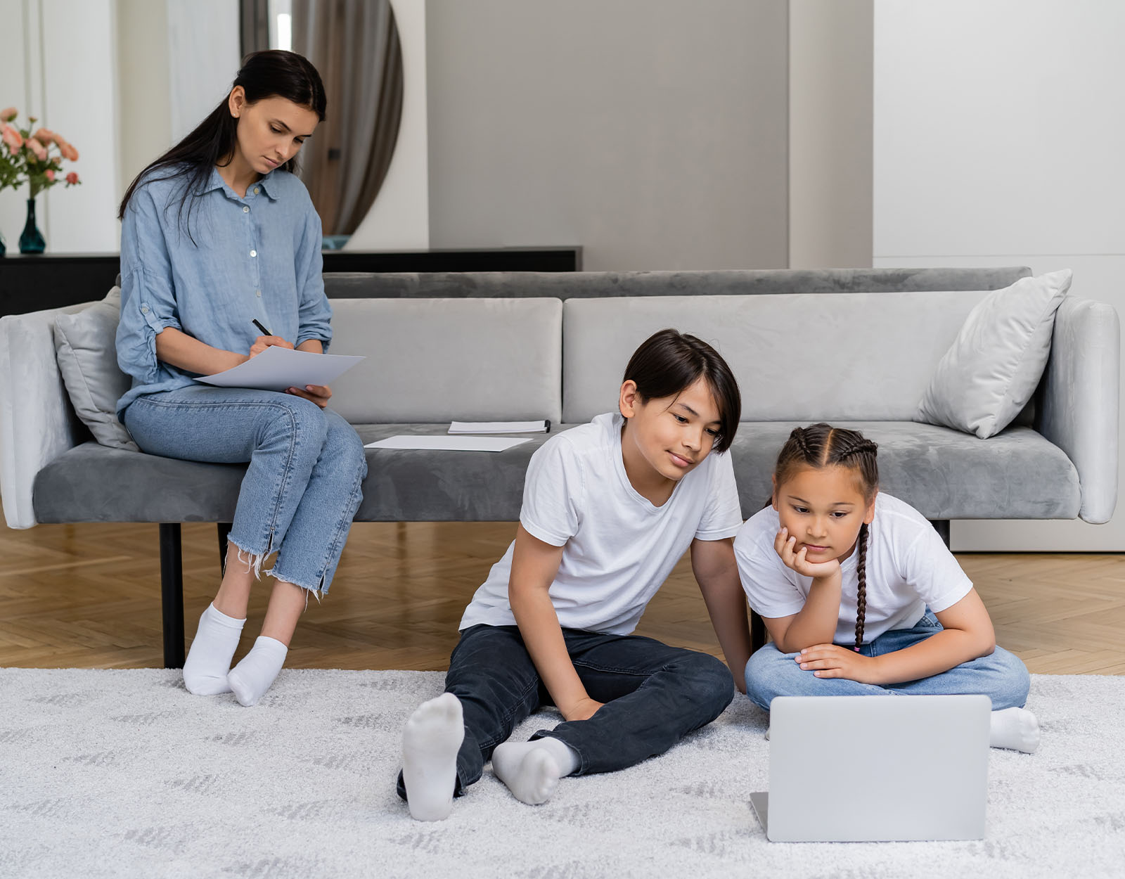 parent looking over while children use technology